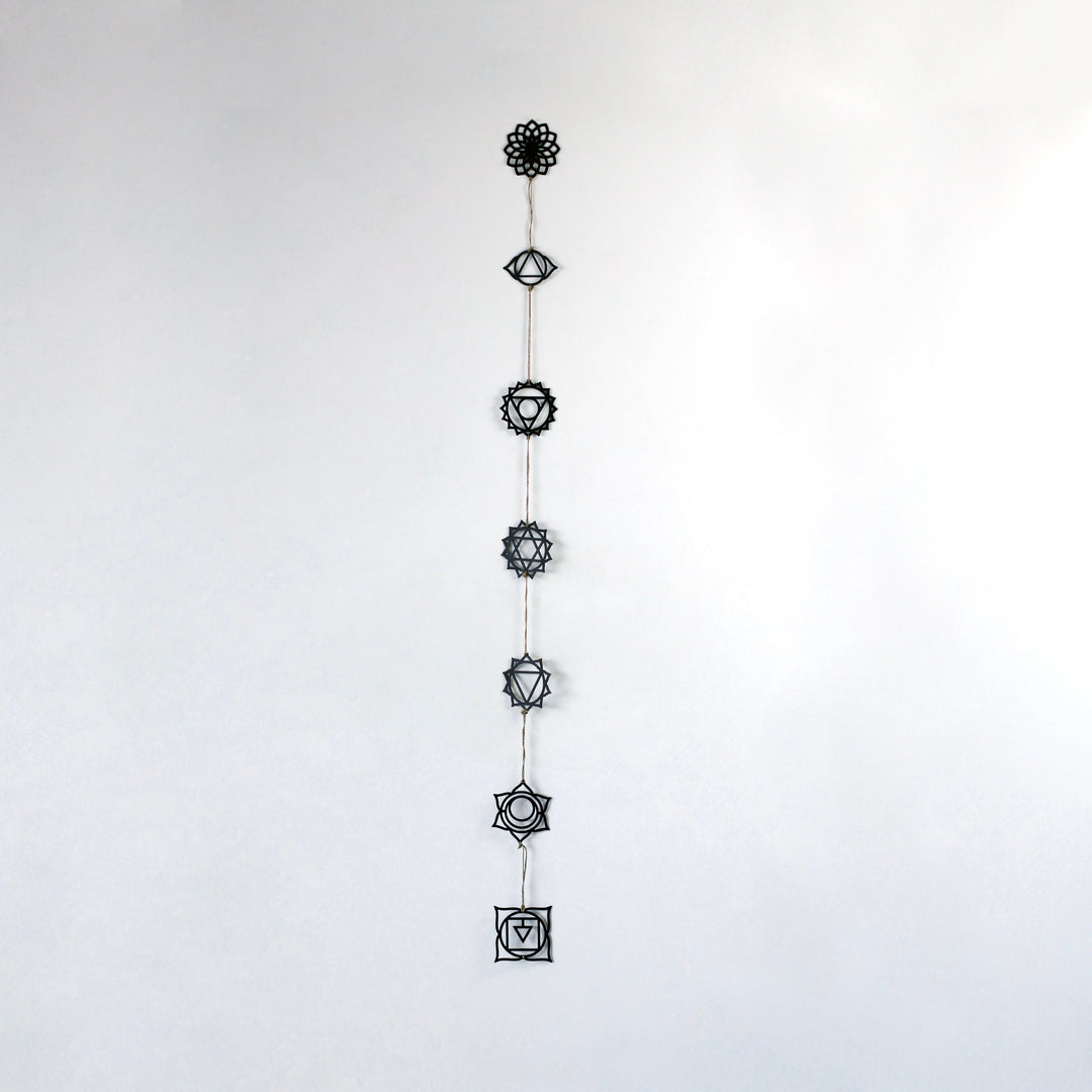 beyaz duvarda alt alta asılmış 7 çakra sembolleri duva dekoru