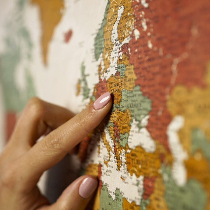 bir kisi retro renkli dunya haritasi kanvas tablo uzerinde avrupa bolgesini isaret ediyor yakin plan colorfullworldstr